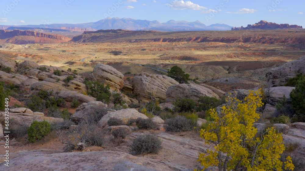 Establishing shot of mountain trail with red rocks background in Delicate Arch, Arches National Park, Utah, North America. Day time on October 2023. Still camera view. ProRes 422 HQ. Establishing shot of mountain trail with red rocks background in Delicate Arch, Arches National Park, Utah, North America. Day time on October 2023. Still camera view. ProRes 422 HQ.