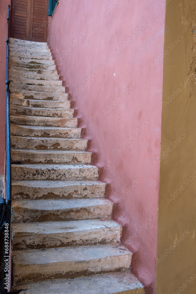 Φωτογραφία White weathered narrow stone stair between pink wall drives to wooden closed door, Greece