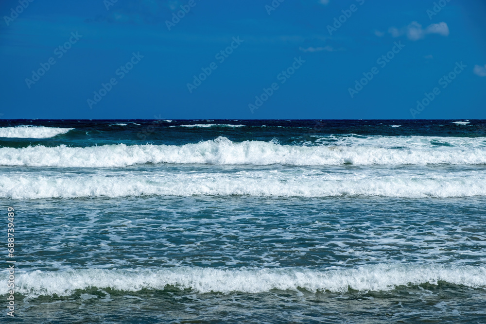 Greece, ripple dark sea water, splashing foam, Greek blue sky background, copy space. Ad template