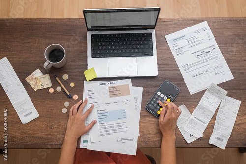 Financial Strategist: A woman, from a top view, meticulously calculates household expenses, managing the family budget and bills on a table photo