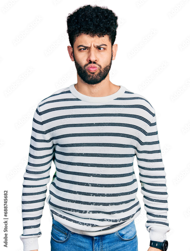 Young arab man with beard wearing casual striped sweater making fish face with lips, crazy and comical gesture. funny expression. Young arab man with beard wearing casual striped sweater making fish face with lips, crazy and comical gesture. funny expression.