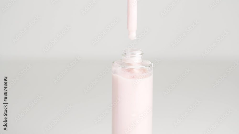 Close up of pipette and the serum bottle. Serum cream in pipette falling in the bottle. Health care cosmetics. Close up of pipette and the serum bottle. Serum cream in pipette falling in the bottle. Health care cosmetics.