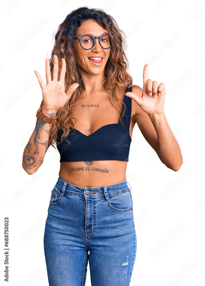 Young hispanic woman with tattoo wearing casual clothes and glasses showing and pointing up with fingers number seven while smiling confident and happy. Young hispanic woman with tattoo wearing casual clothes and glasses showing and pointing up with fingers number seven while smiling confident and happy.