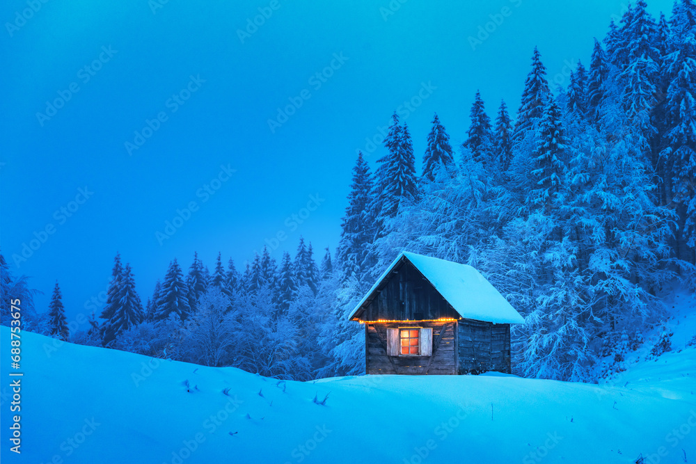 A lonely wooden house surrounded by snowy pine trees in a mountain glade deep within the woods in a wintery landscape. Christmas holiday postcard. Snowy mountains forest A lonely wooden house surrounded by snowy pine trees in a mountain glade deep within the woods in a wintery landscape. Christmas holiday postcard. Snowy mountains forest