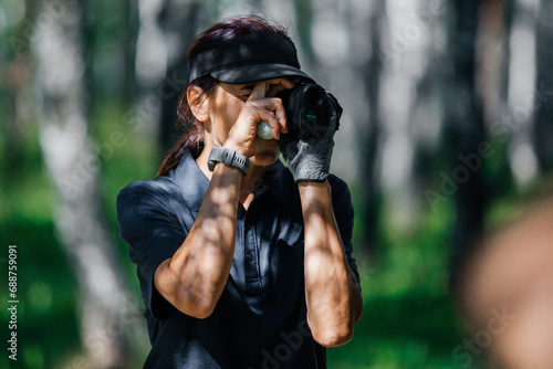 Female golfer looks into rangefinder and measures distance photo