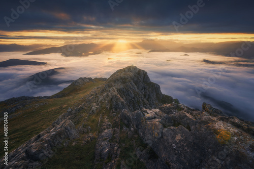 Hiker in Majestic Mountain Sunrise Over Clouds in Urkiola Natural Park, Spain photo