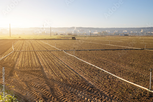 Sunlit agricultural field ready for irrigation photo
