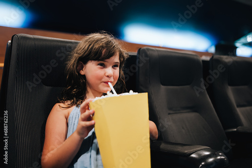 Girl with popcorn enjoying movie in theater