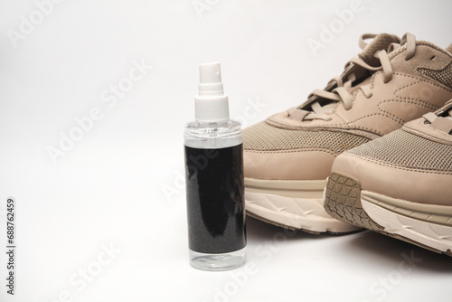 Sneakers and water protection spray on white background. Shoe care