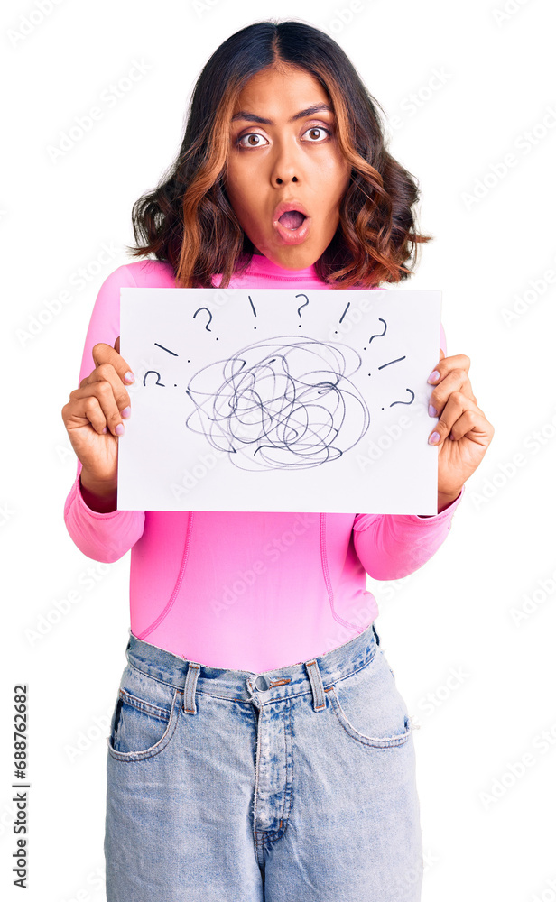 Young beautiful mixed race woman holding scribble draw scared and amazed with open mouth for surprise, disbelief face Young beautiful mixed race woman holding scribble draw scared and amazed with open mouth for surprise, disbelief face