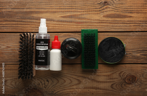 Shoe care products and accessories on wooden background. Top view. Flat lay