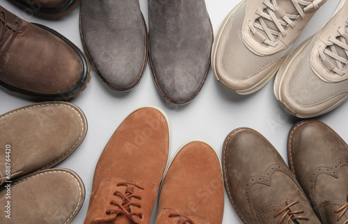 Many pairs of shoes on gray background. Top view.