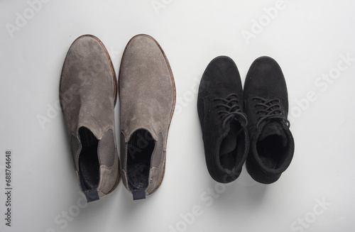 Men's and women's suede boots on a gray background. Top view