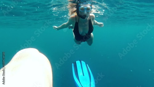 Couple, swimming and snorkeling underwater in ocean for freedom, adventure and exploring in summer. Scuba diving, man or woman together at beach or sea for holiday, vacation or travel in Indonesia photo