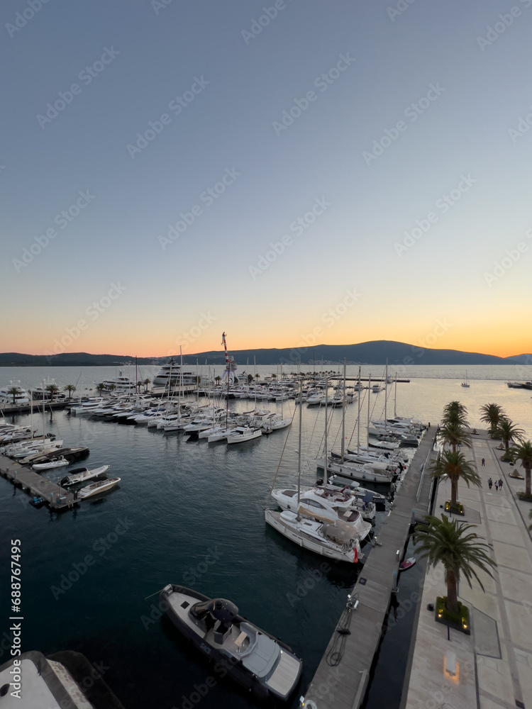 Luxurious marina with yachts at sunset over a mountain range