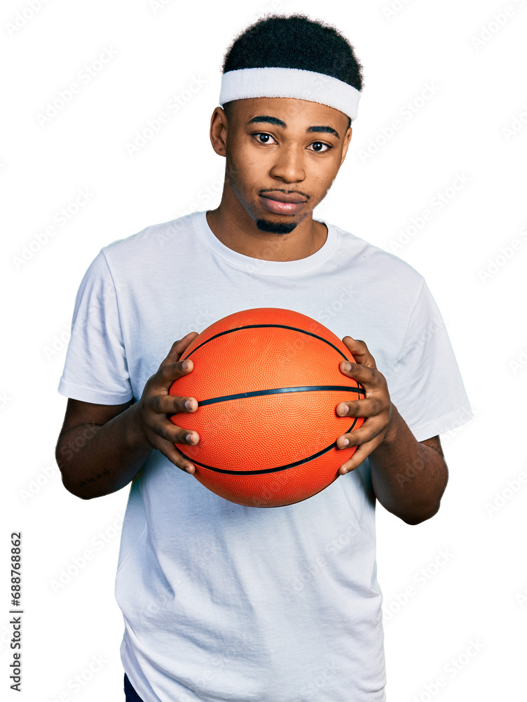 Φωτογραφία Young african american man holding basketball ball relaxed with serious expression on face