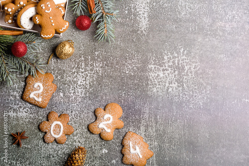 Gingerbread cookies of the form of numbers and 2024. Christmas composition with gingerbread on gray background. Copy space. Flat lay