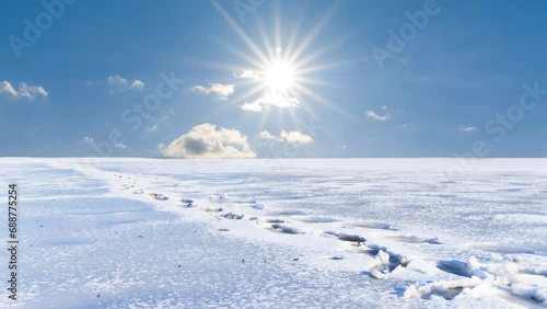 snowbound plain with human track at sunny winter day time lapse scene photo