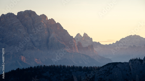Rocky peaks catching the first orange light during sunrise, tight shot, Dolomites, Italy