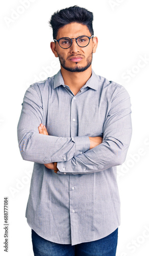 Handsome latin american young man wearing business clothes and glasses skeptic and nervous, disapproving expression on face with crossed arms. negative person. © Krakenimages.com