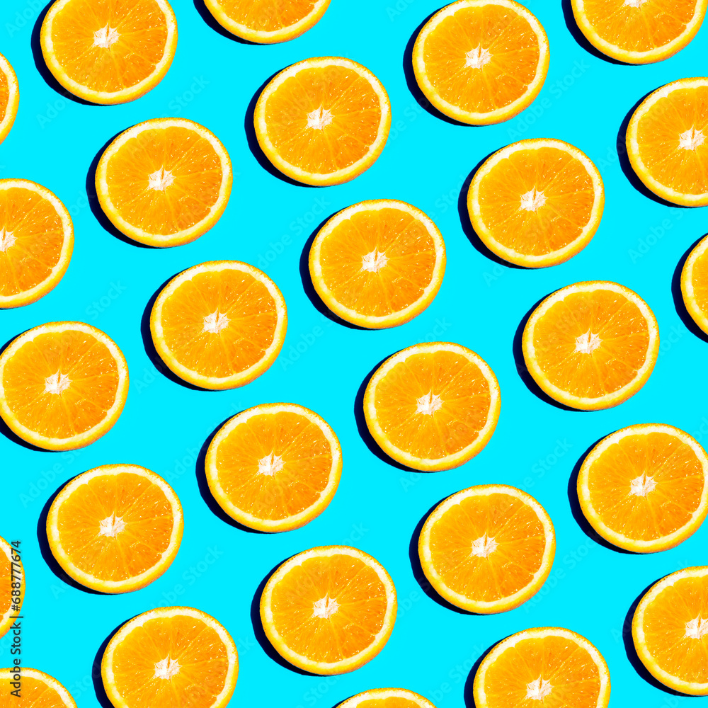 From above slices of vibrant orange citrus fruit arranged in a repetitive pattern on a bright blue background, creating a fresh and summery feel From above slices of vibrant orange citrus fruit arranged in a repetitive pattern on a bright blue background, creating a fresh and summery feel