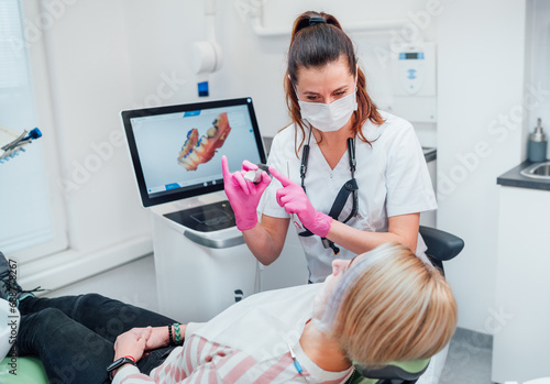 Dentist female doctor in uniform using intraoral 3D dental scanner Machine for clear aligners production. Dental clinic patient visit modern medical ward. Health teeth care, medicare industry concept.