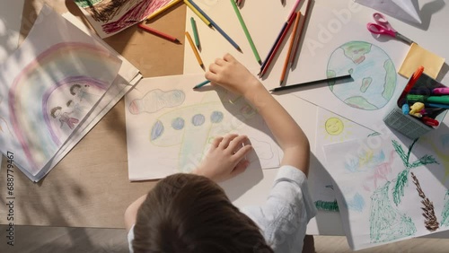 Energetic kid gracefully wields his pencil, immersing himself in world of imagination. Boy with long hair using his imagination, creating art. Fantasy, fine motor skills and boundless inspiration