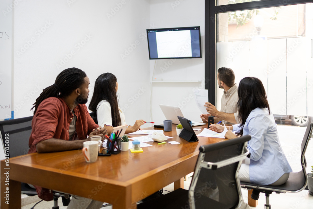 Multiracial colleagues discussing over monitor in office Multiracial colleagues discussing over monitor in office