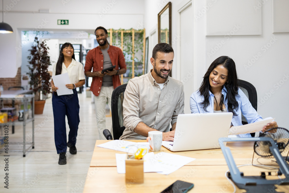 © ADDICTIVE STOCK - Multiracial colleagues discussing in coworking office