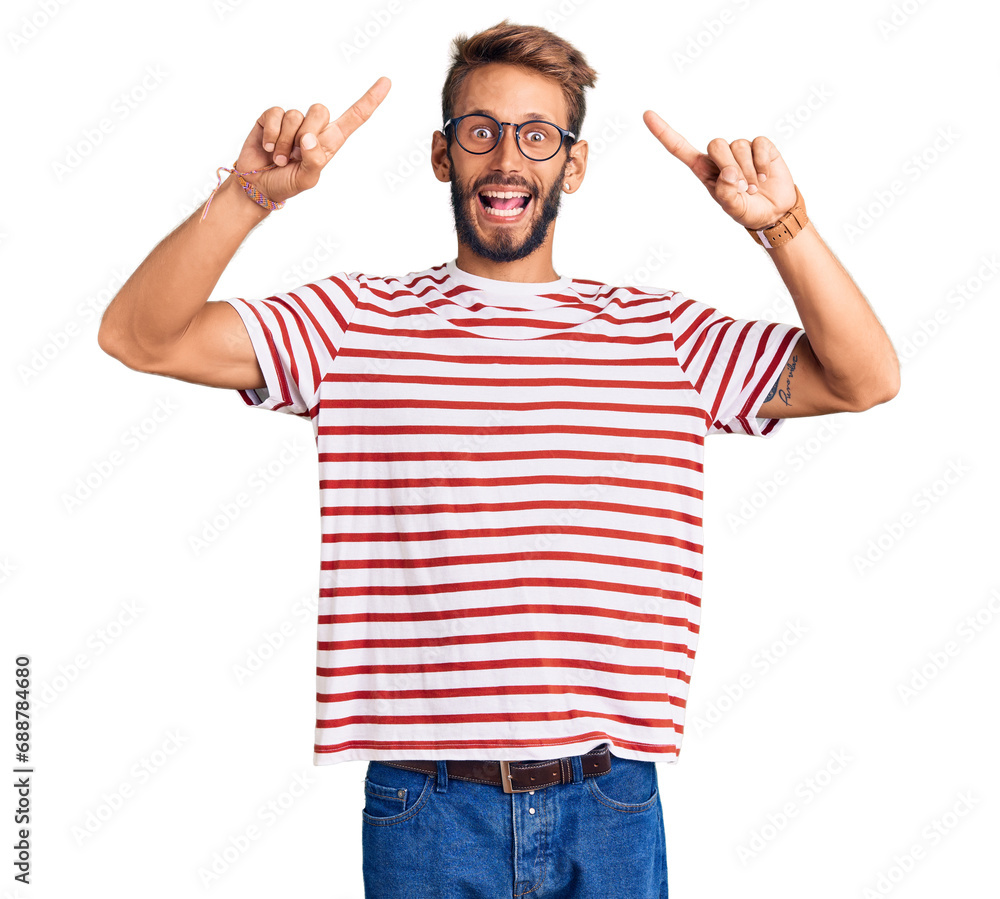 Handsome blond man with beard wearing casual clothes and glasses smiling amazed and surprised and pointing up with fingers and raised arms. Handsome blond man with beard wearing casual clothes and glasses smiling amazed and surprised and pointing up with fingers and raised arms.