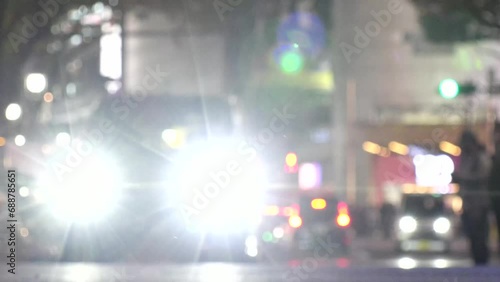 SHIBUYA, TOKYO, JAPAN -NOV 2023 : Time lapse shot of crowd of people walking and street traffic at night. Scenery of busy downtown city. Japanese people, nightlife, traffic and transportation concept. photo