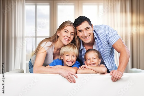Happy young parents and kids resting at home
