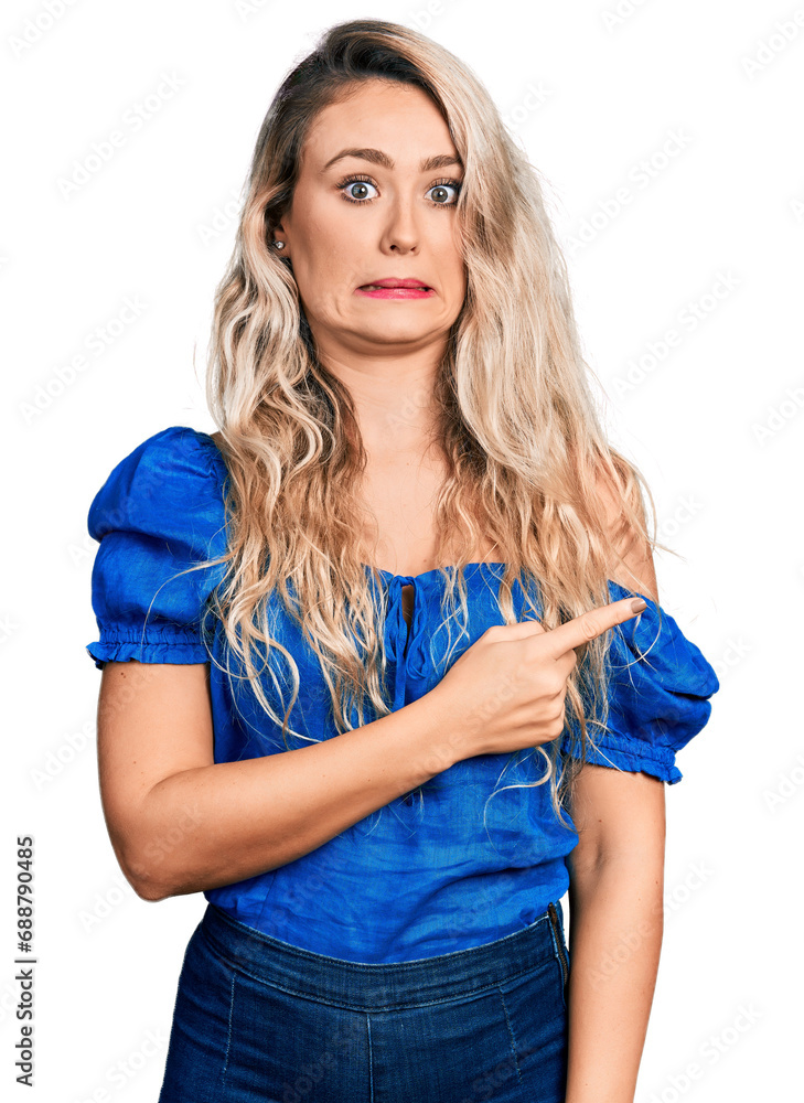 Young blonde woman wearing casual clothes pointing aside worried and nervous with forefinger, concerned and surprised expression Young blonde woman wearing casual clothes pointing aside worried and nervous with forefinger, concerned and surprised expression