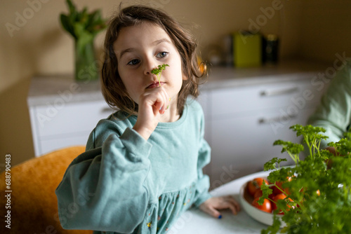 Elementary kid smelling herb at home photo