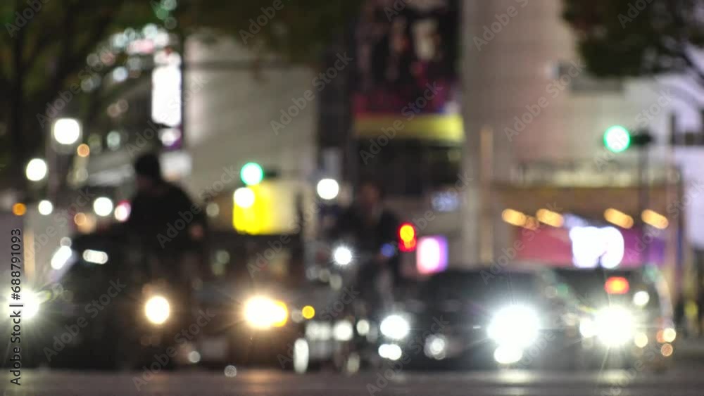 SHIBUYA, TOKYO, JAPAN - NOV 2023 : View of street traffic at night. Many cars, bus, taxi and bike passing by on the road. Japanese transportation and traffic concept video. Out focus shot. SHIBUYA, TOKYO, JAPAN - NOV 2023 : View of street traffic at night. Many cars, bus, taxi and bike passing by on the road. Japanese transportation and traffic concept video. Out focus shot.