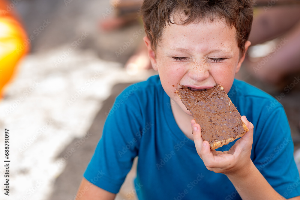 © ADDICTIVE STOCK - Cute hungry boy dressed in casuals with eyes closed eating sweet chocolate spread with bread for breakfast while sitting in restaurant © ADDICTIVE STOCK - Cute hungry boy dressed in casuals with eyes closed eating sweet chocolate spread with bread for breakfast while sitting in restaurant