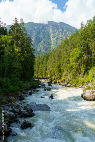 Fast flowing mountain river landscape. Summer time in Alps.   tztal