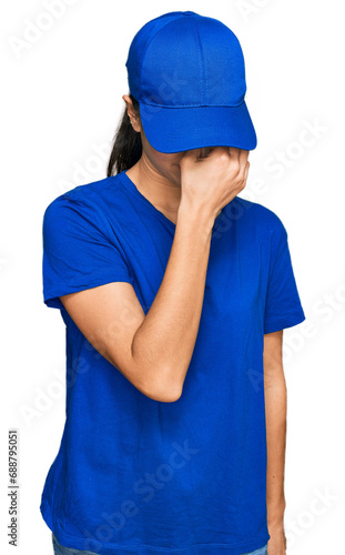 Young hispanic girl wearing delivery courier uniform tired rubbing nose and eyes feeling fatigue and headache. stress and frustration concept.