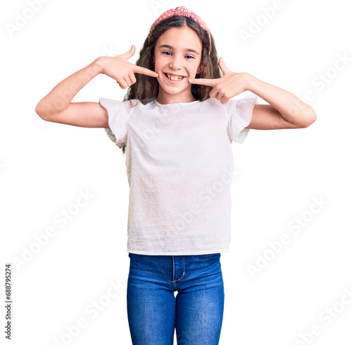 Cute hispanic child girl wearing casual white tshirt smiling cheerful showing and pointing with fingers teeth and mouth. dental health concept.
