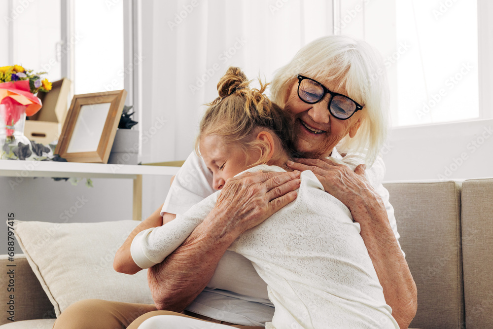 Hugging love home granddaughter sofa grandmother family girl couch happy child Hugging love home granddaughter sofa grandmother family girl couch happy child