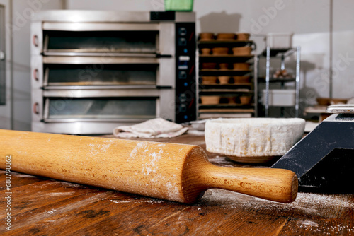 Rolling pin on wooden table in bakery photo
