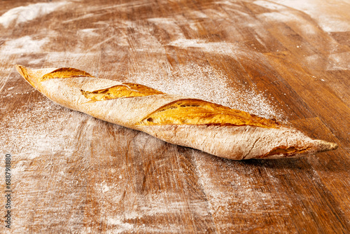 Fresh crunchy baguette on table in bakery photo
