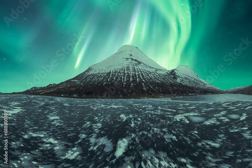 Enchanting northern lights over snow-capped Icelandic peak