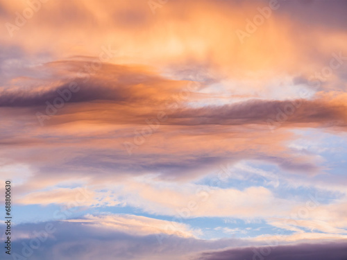 Sweeping orange sunset skies with soft cloud patterns