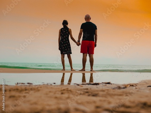 Père et fille se donnent la main sur la plage © jonathan