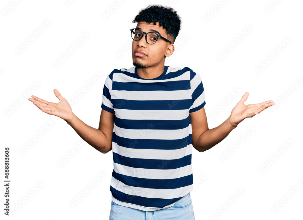 Young african american man wearing casual clothes and glasses clueless and confused expression with arms and hands raised. doubt concept. Young african american man wearing casual clothes and glasses clueless and confused expression with arms and hands raised. doubt concept.
