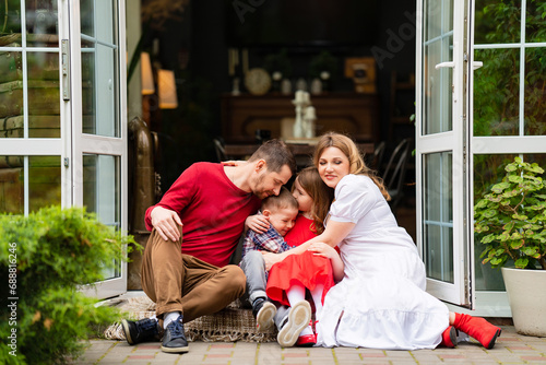 Beautiful and happy family on the porch of the house.  © andrey