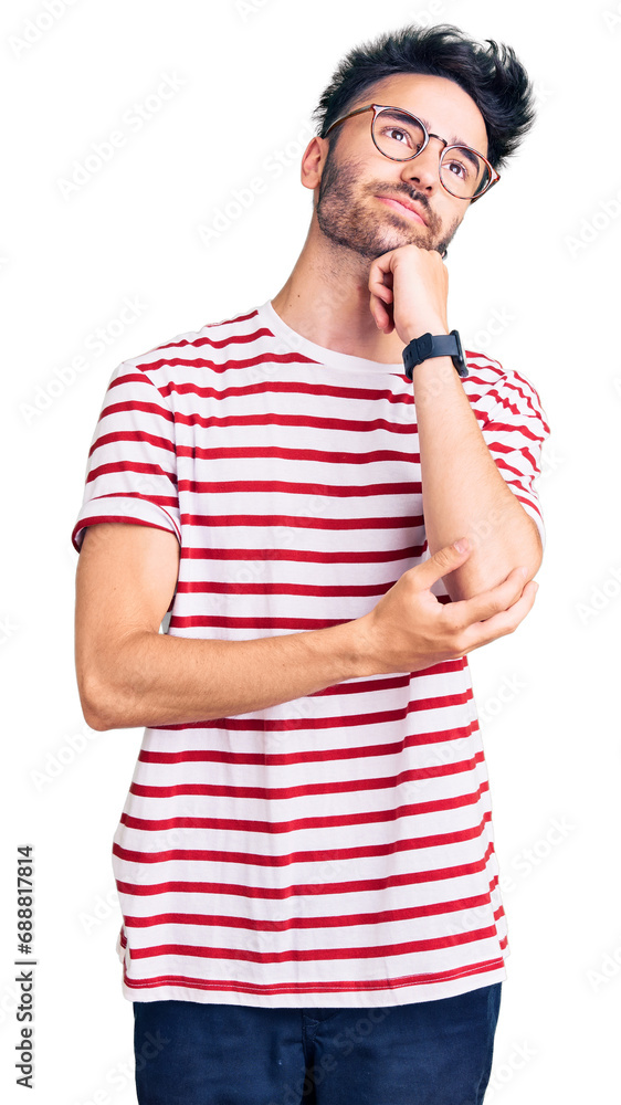 Young hispanic man wearing casual clothes with hand on chin thinking about question, pensive expression. smiling and thoughtful face. doubt concept. Young hispanic man wearing casual clothes with hand on chin thinking about question, pensive expression. smiling and thoughtful face. doubt concept.