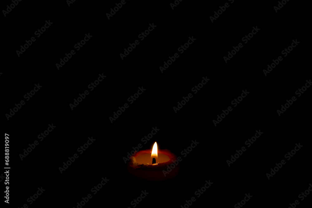 Burning red candle flame with dark horizontal background with area for copy space Burning red candle flame with dark horizontal background with area for copy space