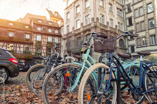 Canvas Print Many vintage modern retro bicycles parked at Alsace Strasbourg city street against medieval old ancient fachwerk building